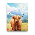 A Nicheink Highland Cow Canvas Wall Art in a field with mountains in the background.